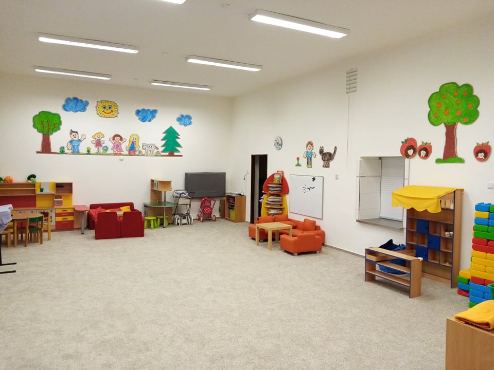 Pohled na zadní část třídy, kde je velký prostor s kobercem vhodný pro hru a učení